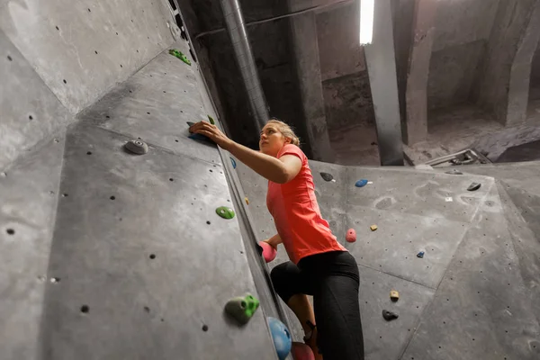 Mujer joven haciendo ejercicio en el gimnasio de escalada interior —  Fotos de Stock