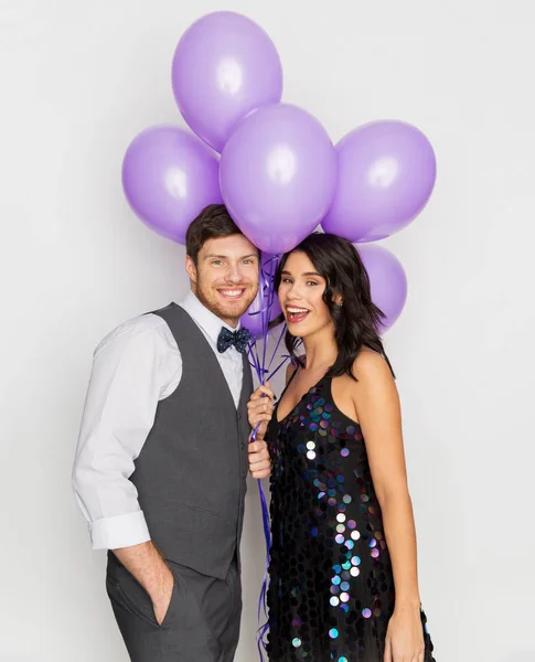 Gelukkige paar met ultra violet ballonnen op feestje — Stockfoto