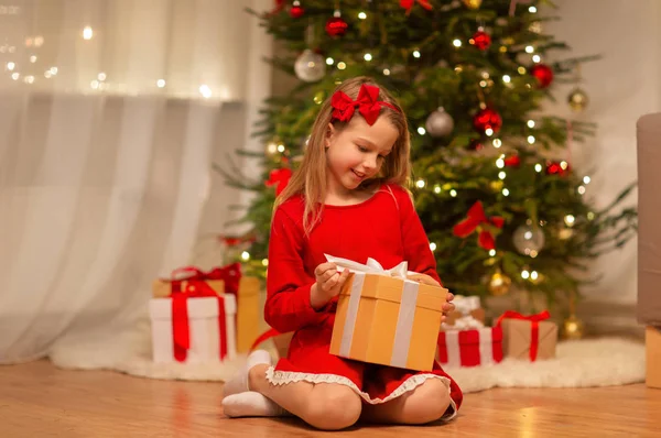 Smiling girl with christmas gift at home — Stock Photo, Image