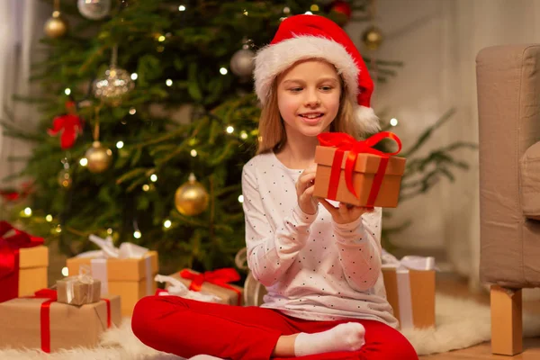 Fille souriante dans le chapeau de Père Noël avec cadeau de Noël Images De Stock Libres De Droits