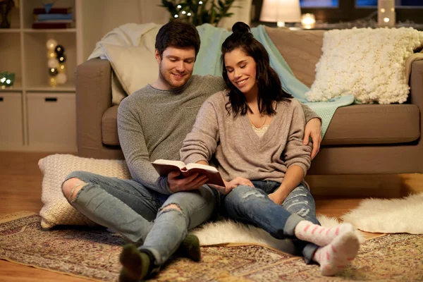 Happy couple reading book at home — Stock Photo, Image