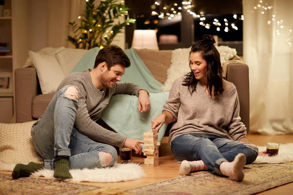 Feliz pareja jugando bloque-apilamiento juego en casa — Foto de Stock