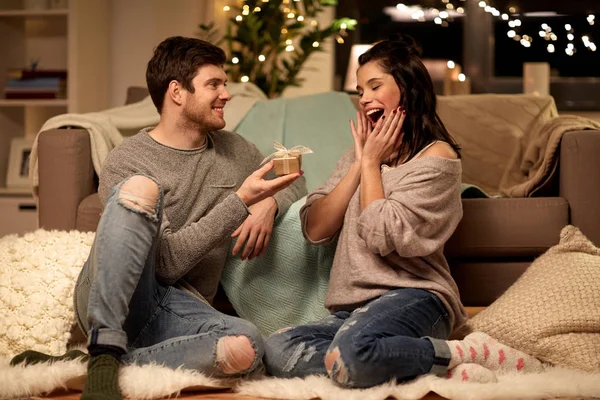 Feliz pareja con caja de regalo en casa — Foto de Stock