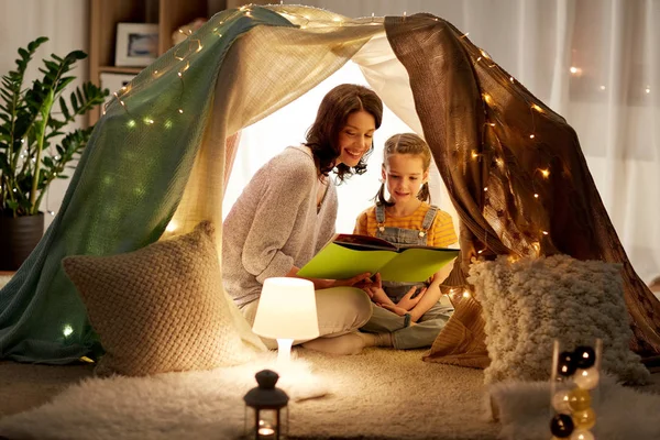 Glückliche Familie liest Buch im Kinderzelt zu Hause — Stockfoto