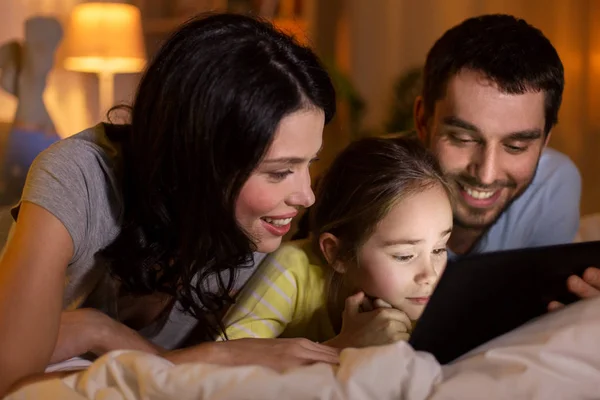 家中晚上有平板电脑在床上的家庭 — 图库照片