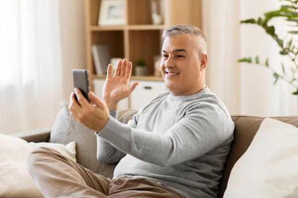 Uomo con video chat su smartphone a casa — Foto Stock