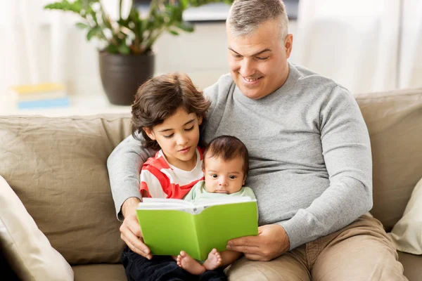 Happy father with sons reading book at home — Stock Photo, Image