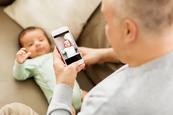 Pai fotografar bebê por smartphone — Fotografia de Stock