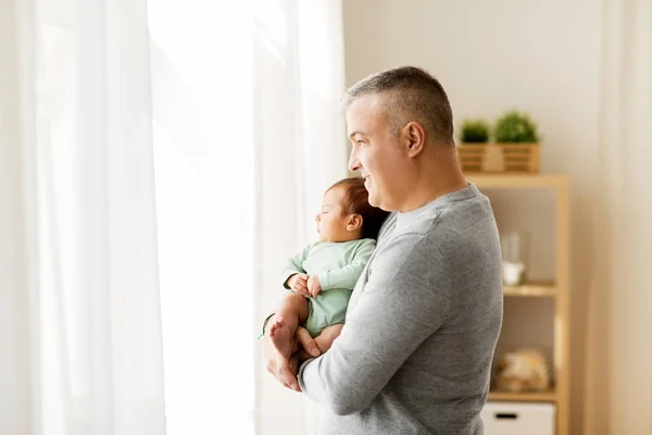 Lykkelig far holder med lille baby søn hjemme - Stock-foto