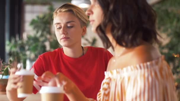 Жінки друзі п'ють каву і розмовляють в кафе — стокове відео