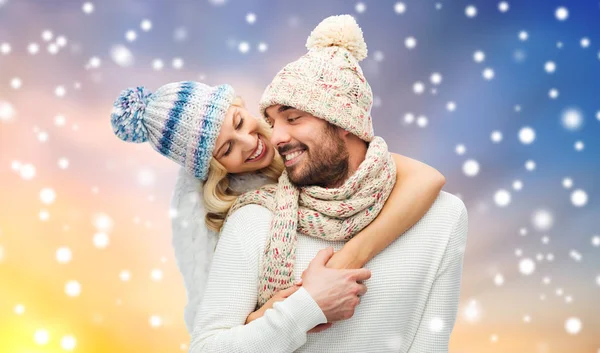 Casal feliz em roupas de inverno abraçando sobre a neve — Fotografia de Stock