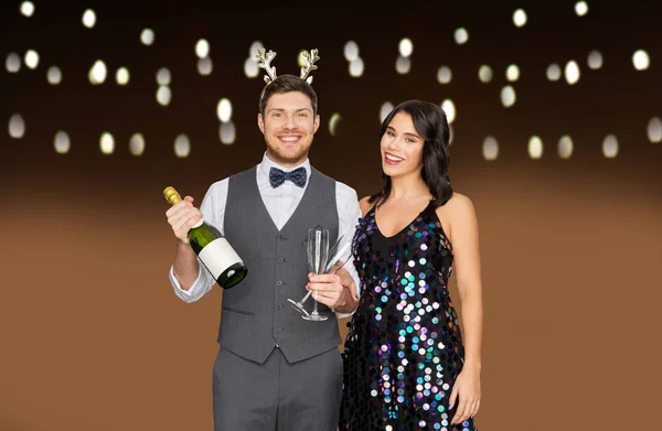 Casal com garrafa de champanhe na festa de Natal — Fotografia de Stock