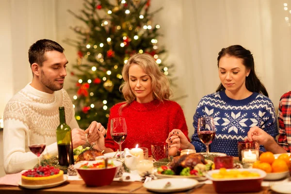 Amigos rezando antes do jantar de Natal em casa — Fotografia de Stock