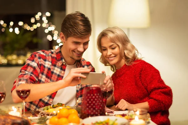 Casal com smartphone em casa jantar de Natal — Fotografia de Stock