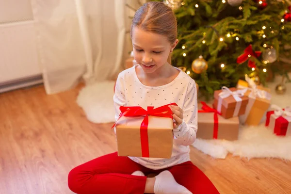 Menina sorridente com presente de Natal em casa — Fotografia de Stock