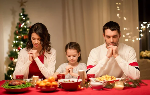 Family praying before meal at christmas dinner — Stock Photo, Image