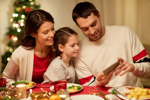 Family with smartphone having christmas dinner — Stock Photo, Image