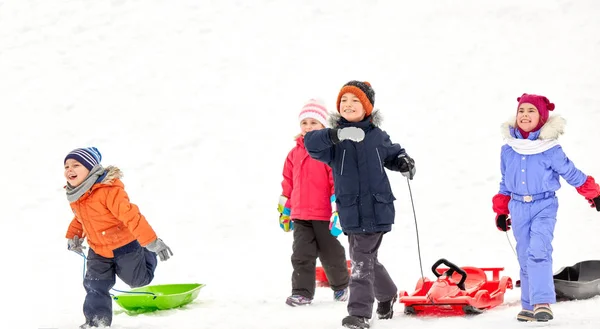 Щасливі маленькі діти зі сідлами взимку — стокове фото