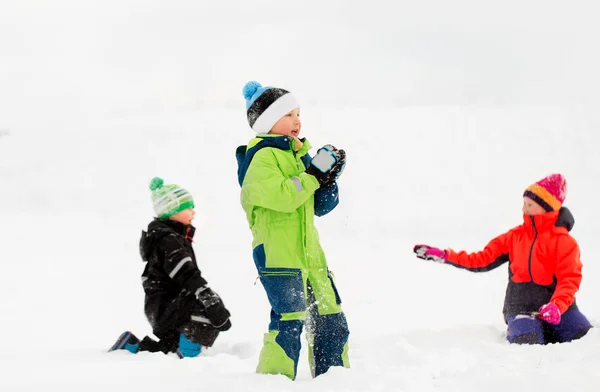 Fröhliche kleine Kinder, die im Winter draußen spielen — Stockfoto