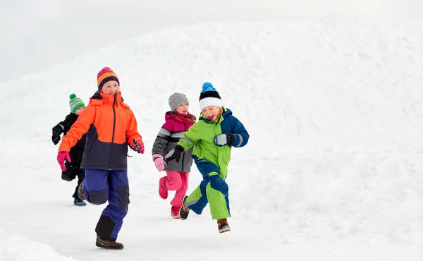 Niños pequeños y felices corriendo al aire libre en invierno —  Fotos de Stock