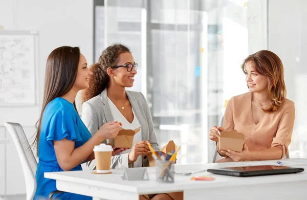Happy businesswomen eating take out food at office — Stock Photo, Image