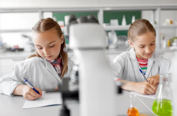 Dos niñas estudiando química en el laboratorio de la escuela — Foto de Stock