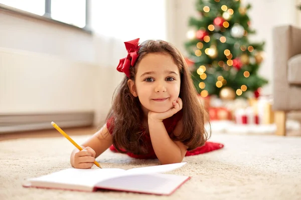 Bambina che scrive la lista dei desideri di Natale a casa — Foto Stock