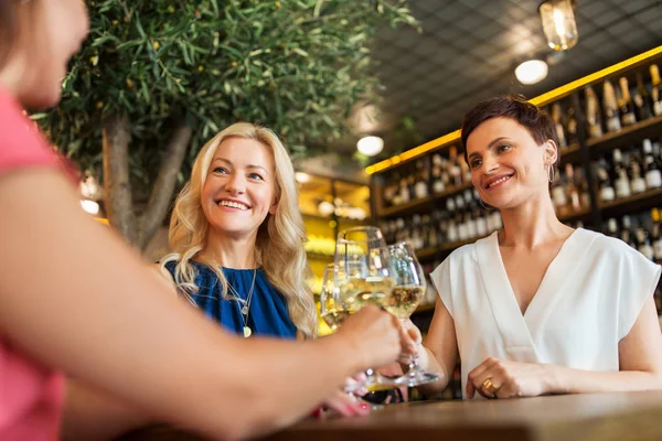Счастливые женщины пьют вино в баре или ресторане — стоковое фото