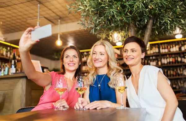 ワインバーで、スマート フォンで selfie を取っている女性 — ストック写真
