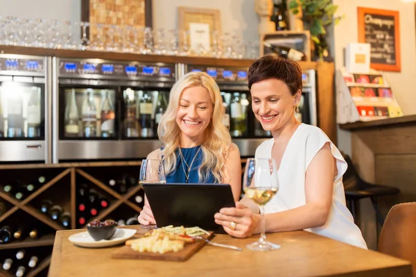 Kobiety z komputera typu tablet w winiarni lub restauracji — Zdjęcie stockowe