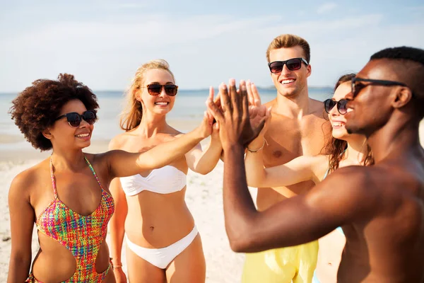 Glada vänner att göra high five på sommaren beach — Stockfoto