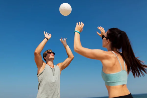 Šťastný pár hrát volejbal na pláži v létě — Stock fotografie