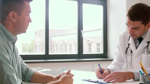 Dokter schrijven recept voor de patiënt bij kliniek — Stockvideo