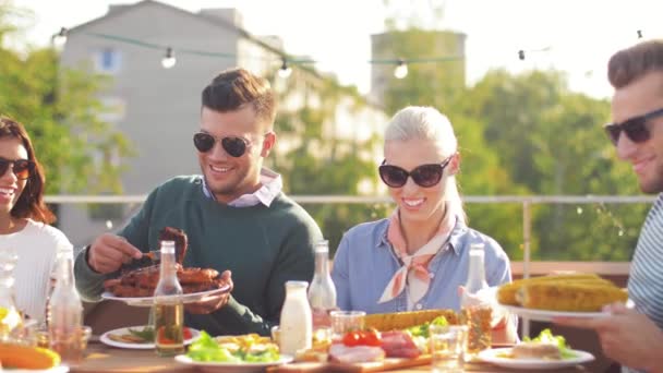 Amici felici mangiare e bere alla festa sul tetto — Video Stock