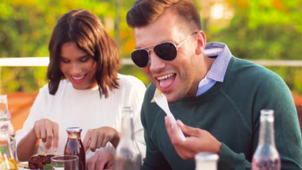 Amigos felices comiendo en la fiesta en la azotea — Vídeos de Stock