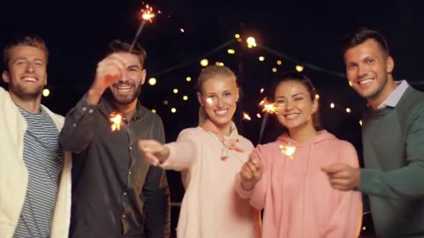 Amigos felices con bengalas en la fiesta en la azotea — Vídeo de stock