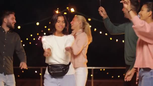Freunde mit Wunderkerzen tanzen auf Dachparty — Stockvideo