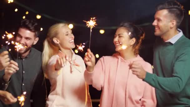Gelukkige vrienden met wonderkaarsen op dak feestje — Stockvideo