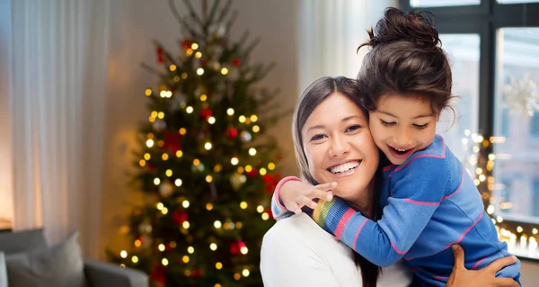 Lycklig mamma kramar hennes dotter på jul — Stockfoto