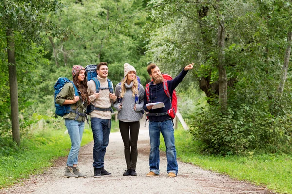 Vänner eller resenärer vandring med ryggsäckar och karta — Stockfoto