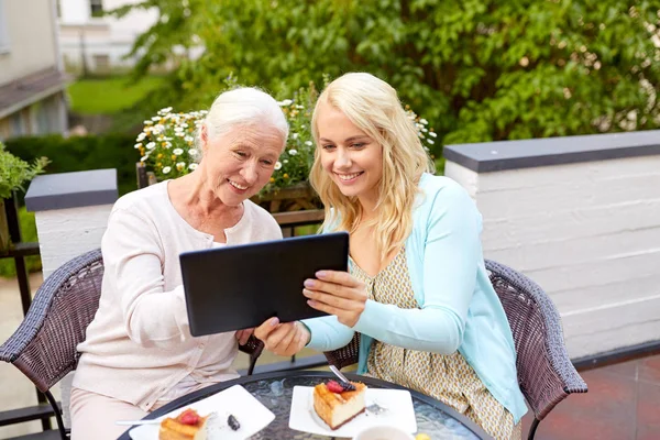 Dochter met tablet pc en senior moeder in café — Stockfoto