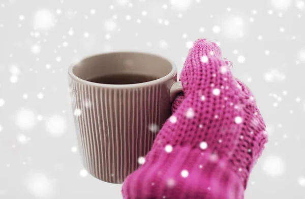 Fechar a mão no inverno mitene segurando caneca de chá — Fotografia de Stock