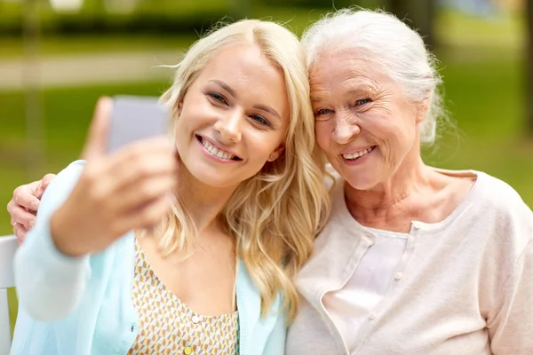 Córka i matka starszy biorąc selfie w parku — Zdjęcie stockowe