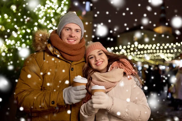 Glada unga par med kaffe på julmarknad — Stockfoto