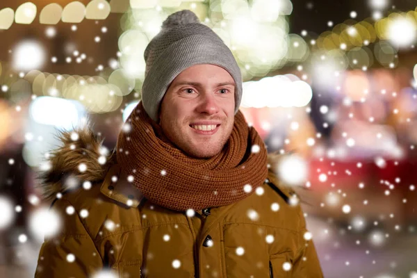 Χαρούμενος νεαρός άνδρας πάνω από τα φώτα των Χριστουγέννων το χειμώνα — Φωτογραφία Αρχείου
