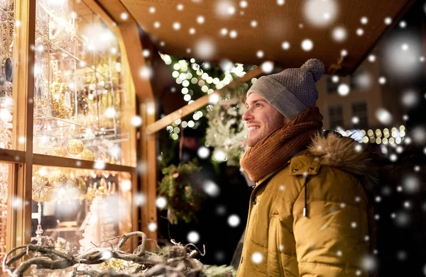 Щасливий чоловік дивиться на вікно різдвяного магазину — стокове фото