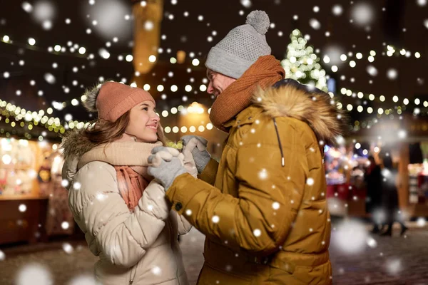 Щаслива пара тримає руки на різдвяному ринку — стокове фото