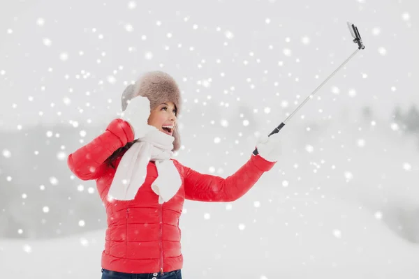 Szczęśliwa kobieta z selfie stick na zewnątrz w zimie — Zdjęcie stockowe