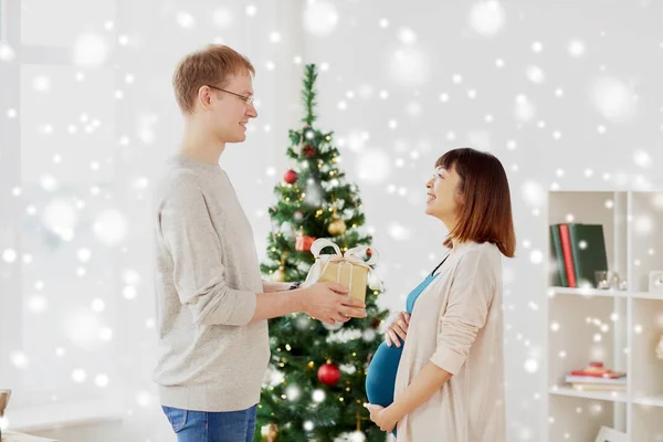 Σύζυγος δίνει χριστουγεννιάτικο δώρο στην έγκυο γυναίκα — Φωτογραφία Αρχείου