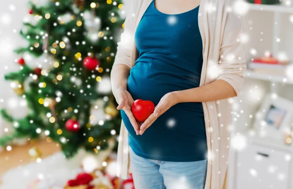 Close up van zwangere vrouw met hart met Kerstmis — Stockfoto